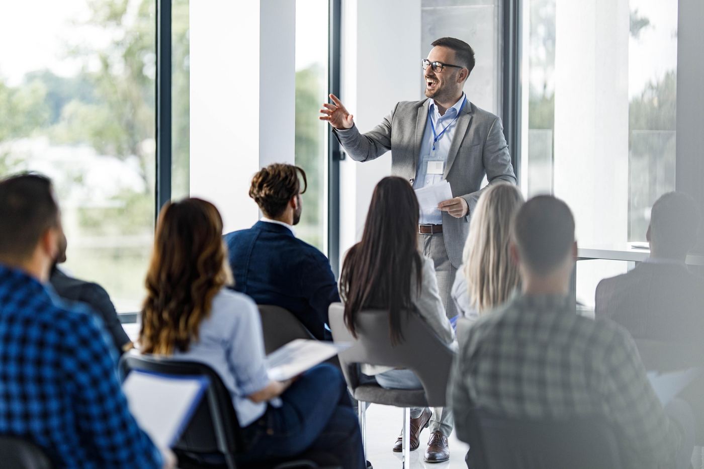 Trainer engaging a laughing audience in a bright training room