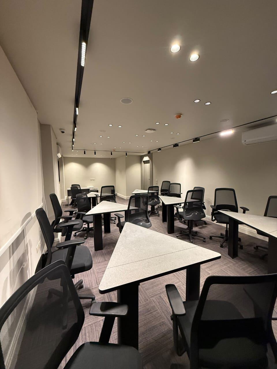 Training hall set in group pods with modular triangle tables