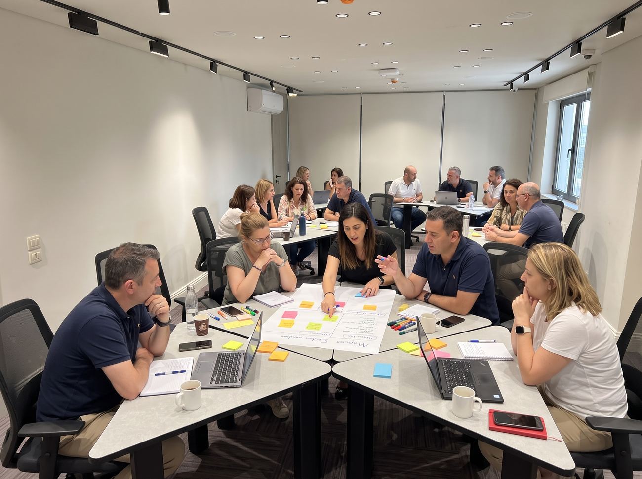 Managers mapping ideas with sticky notes in group pods